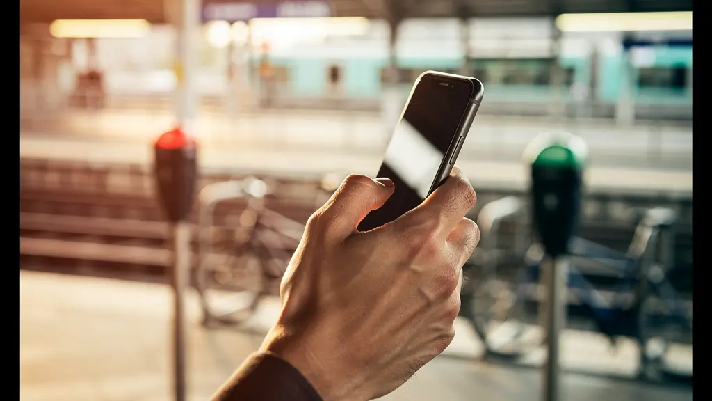 Hand holding smartphone with transportation payment options in urban setting